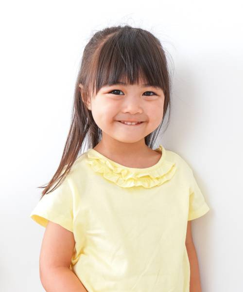 A child smiling on a gray background